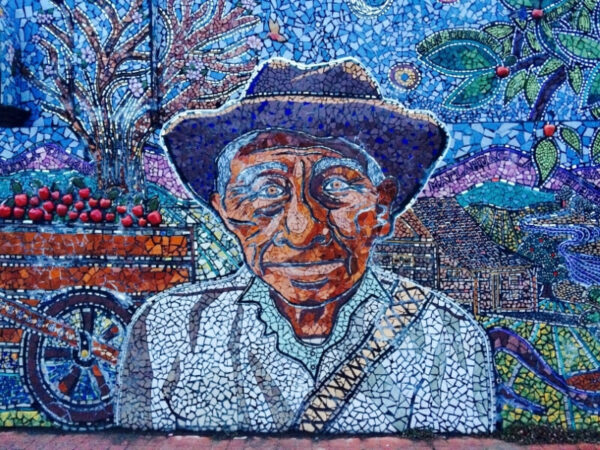 Mosaic wall of a man in a garden