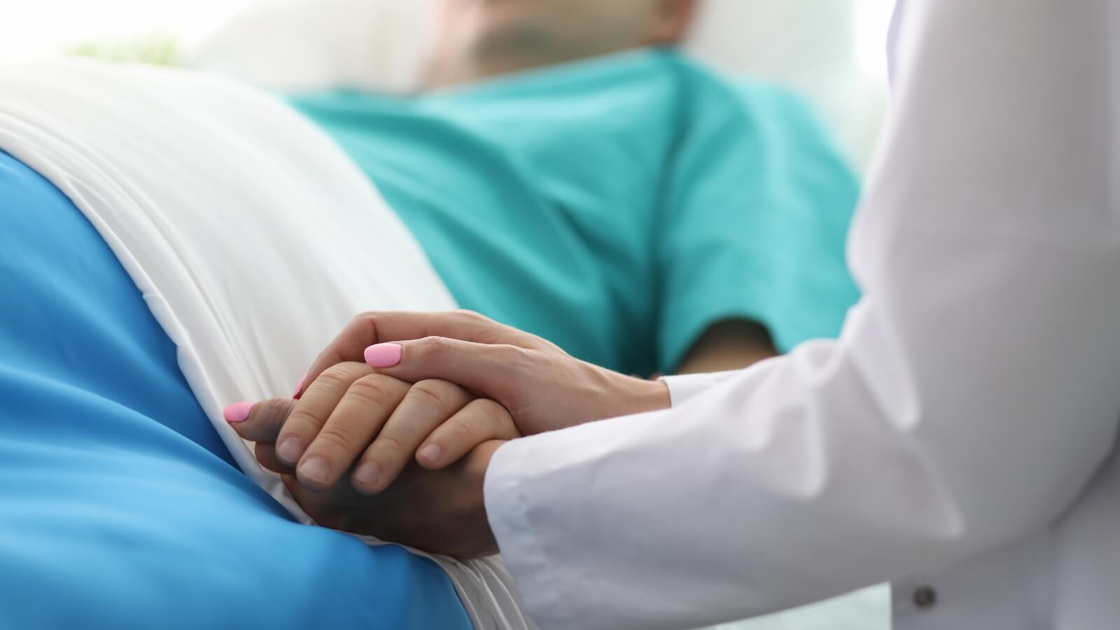 holding the hand of patient