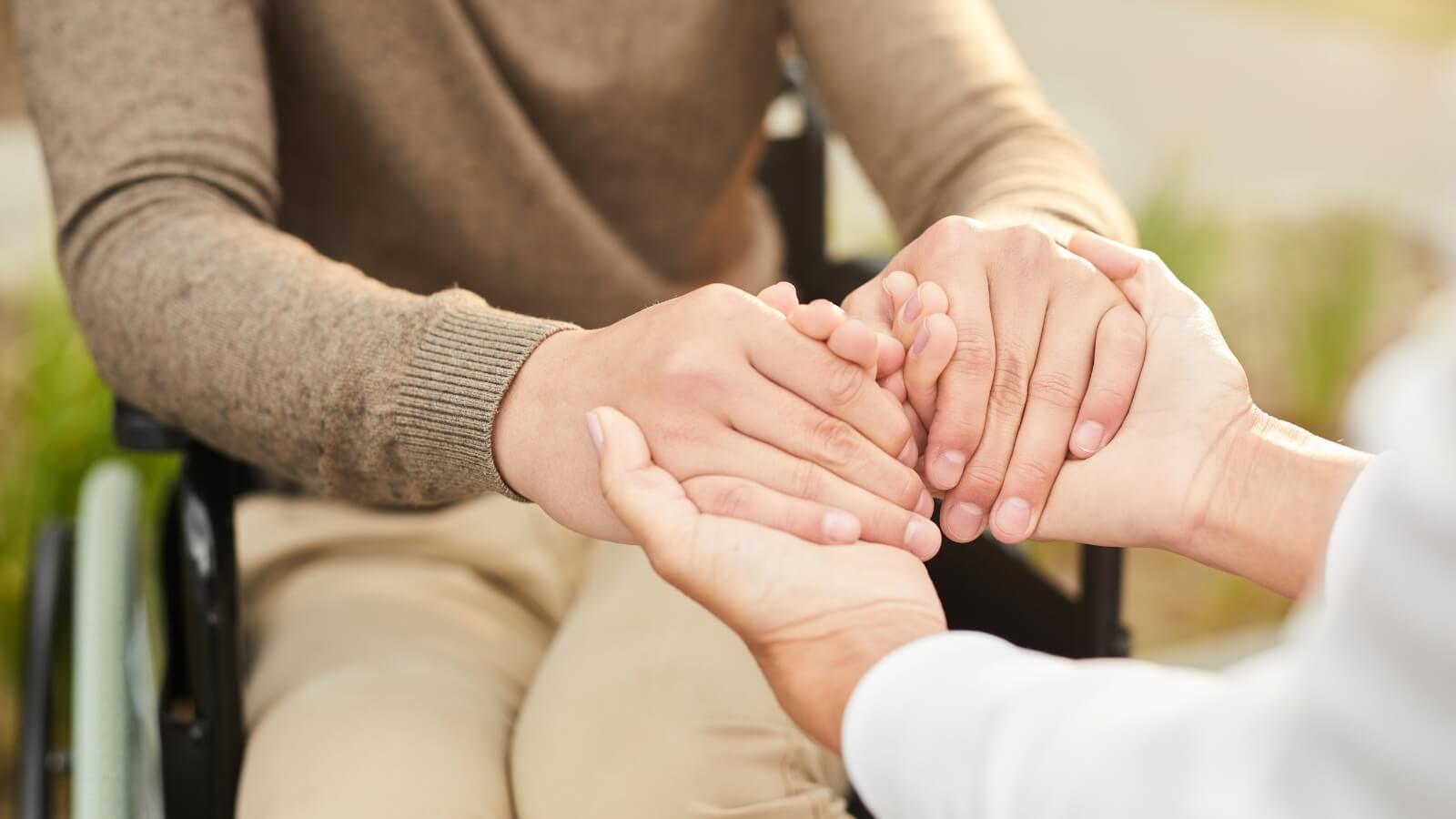 holding hands with person in a wheelchair